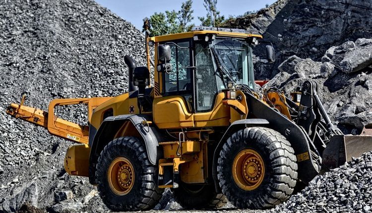 Front-end loader in front of rocks