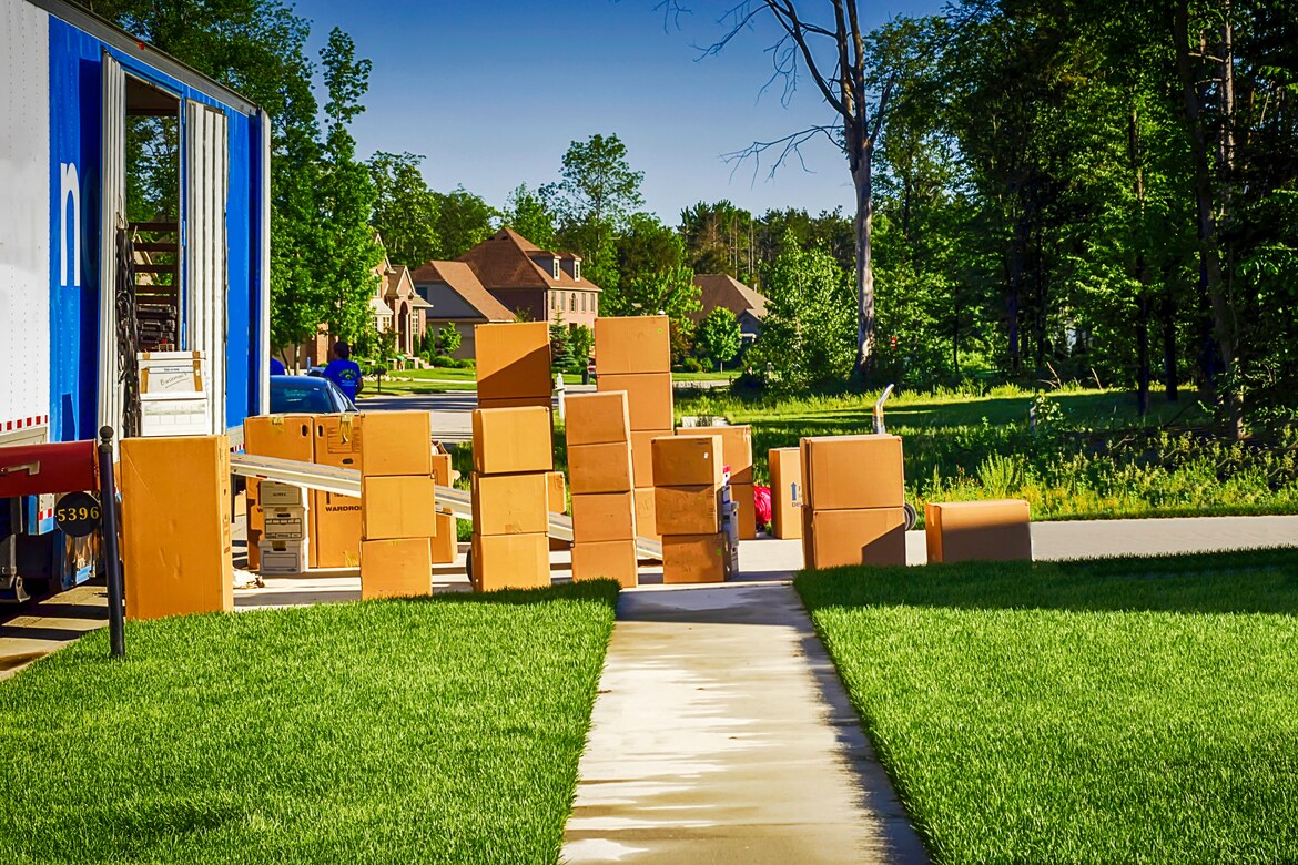photo of moving boxes in yard next to a moving truck