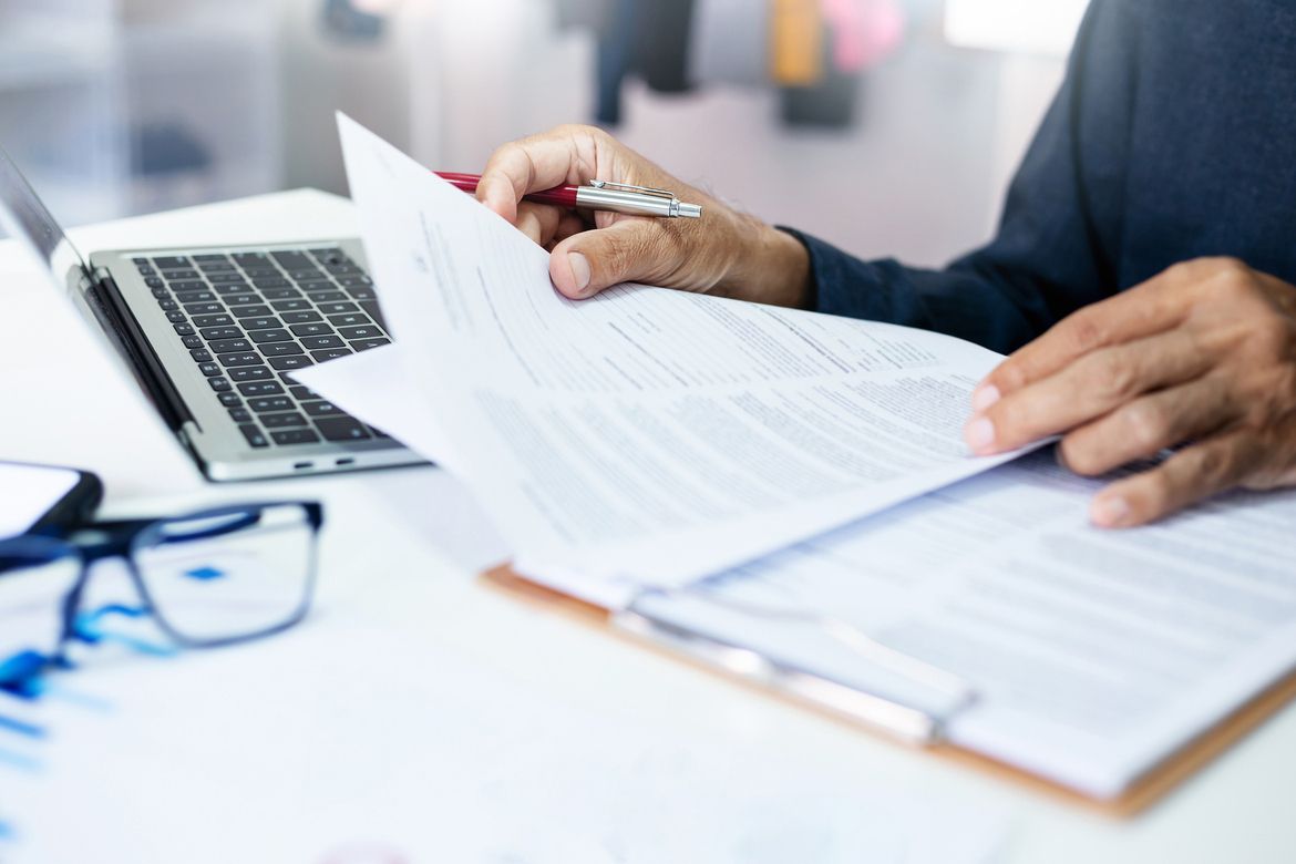 A business owner looking over insurance documents for 2026 and considering commercial umbrella insurance.