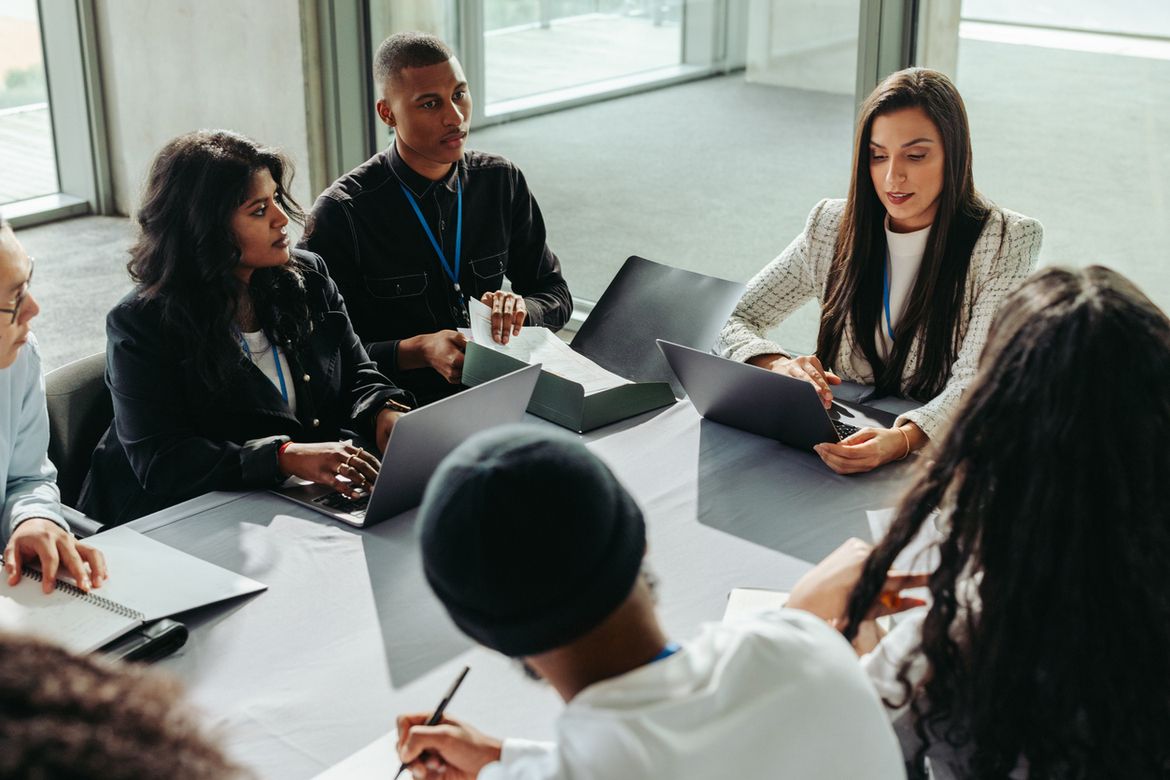 A consultant presents strategy to a business team at a conference desk, representing professional liability exposure