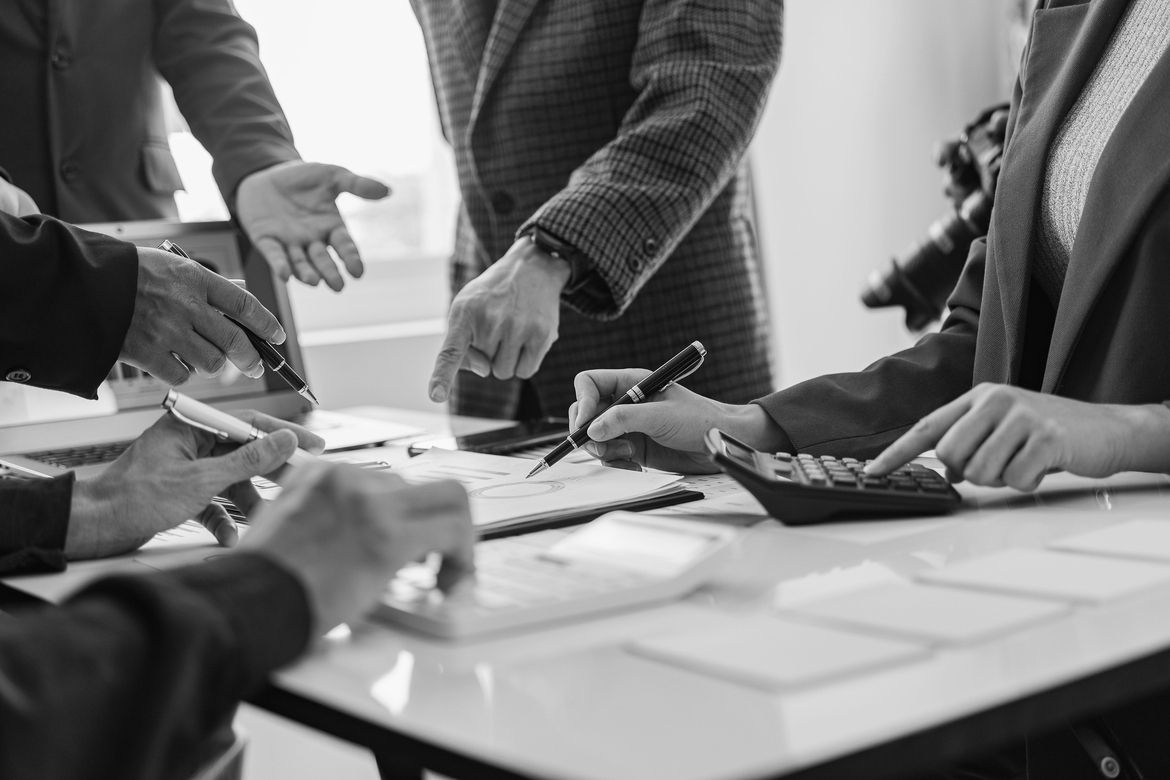A startup board meeting; directors, officers, and founders gather around a table to discuss matters like D&O insurance