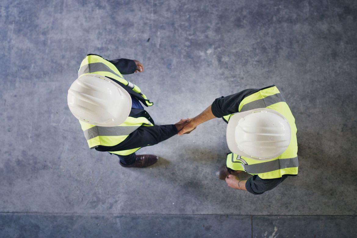 Aerial view of a construction worker shaking hands with an independent contractor