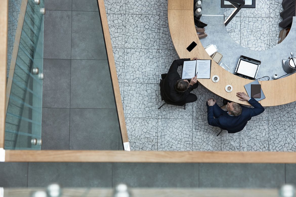 Top-down view of a startup founder reviewing an insurance checklist for his early-stage business