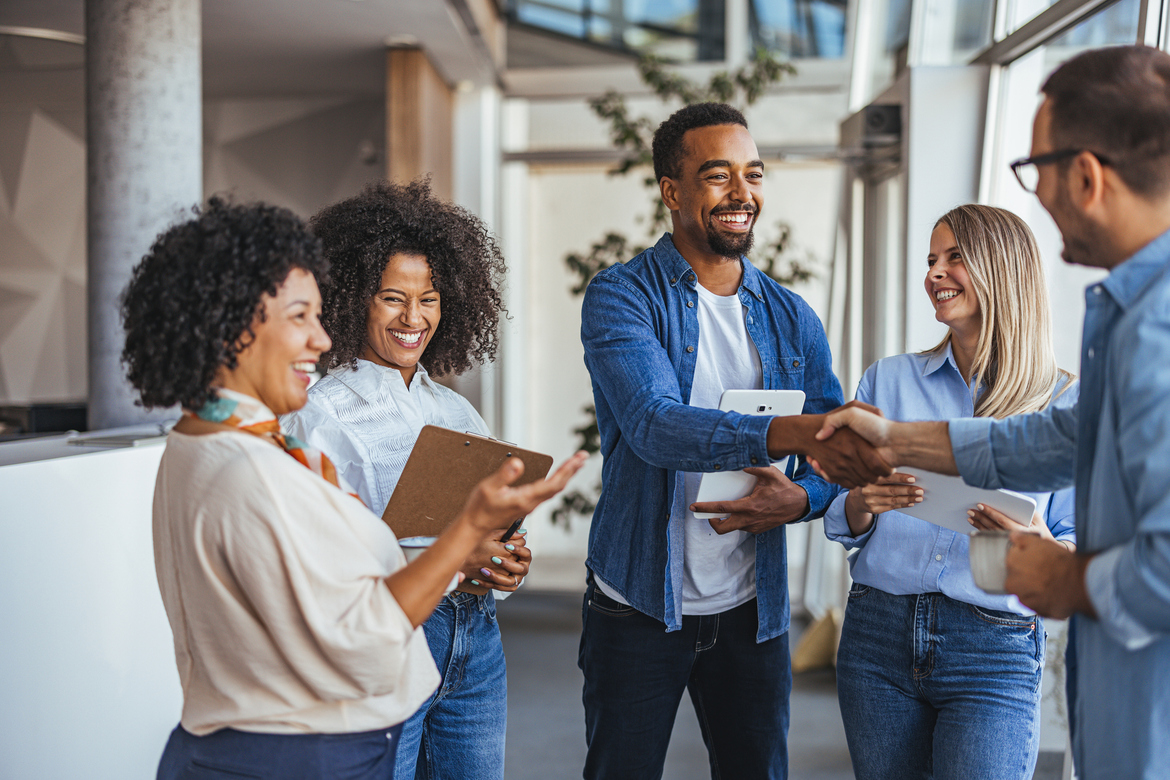Startup founder and employees shaking hands with investor