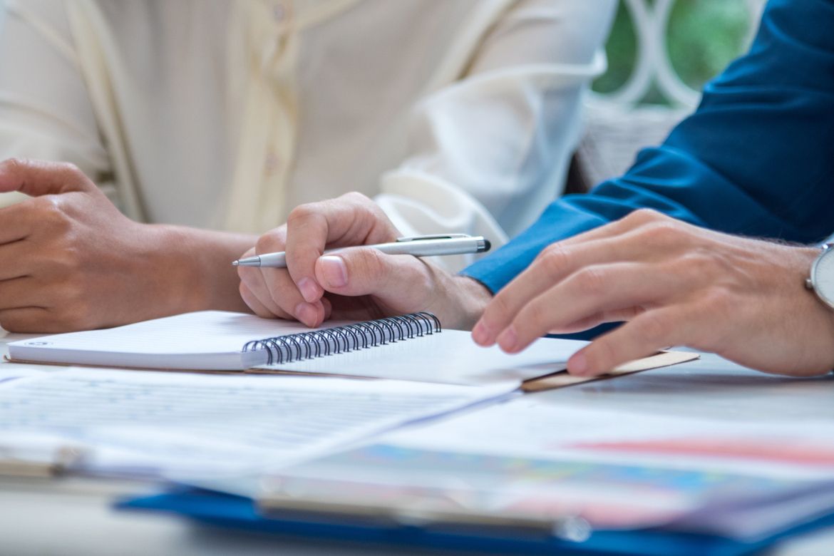 Small business owners at a desk review documents, including workers’ compensation insurance requirements